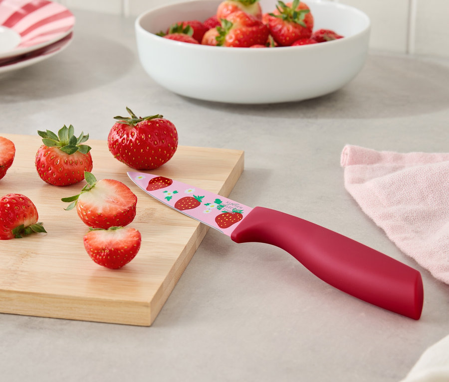 Jahody a nůž s jahodovým vzorem na prkénku.