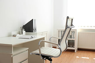 Moderní, ergonomická kancelářská židle s bílým sedákem u bílého stolu.