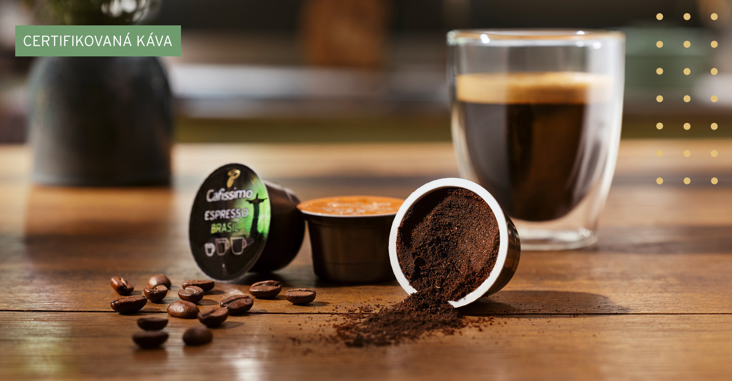 Glas Kaffee steht mit zwei Cafissimo Kapsen auf einem Tisch